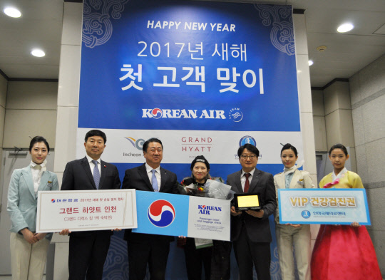 ‘새해 첫 고객 맞이 행사’에 참가한 김종대 대한항공 인천공항지역본부장(왼쪽에서 세번째) 등 관계 직원들이 대한항공 새해 첫 고객 중국인 리징징씨(사진 가운데)와 함께 기념 사진을 찍고 있다. <대한항공 제공>